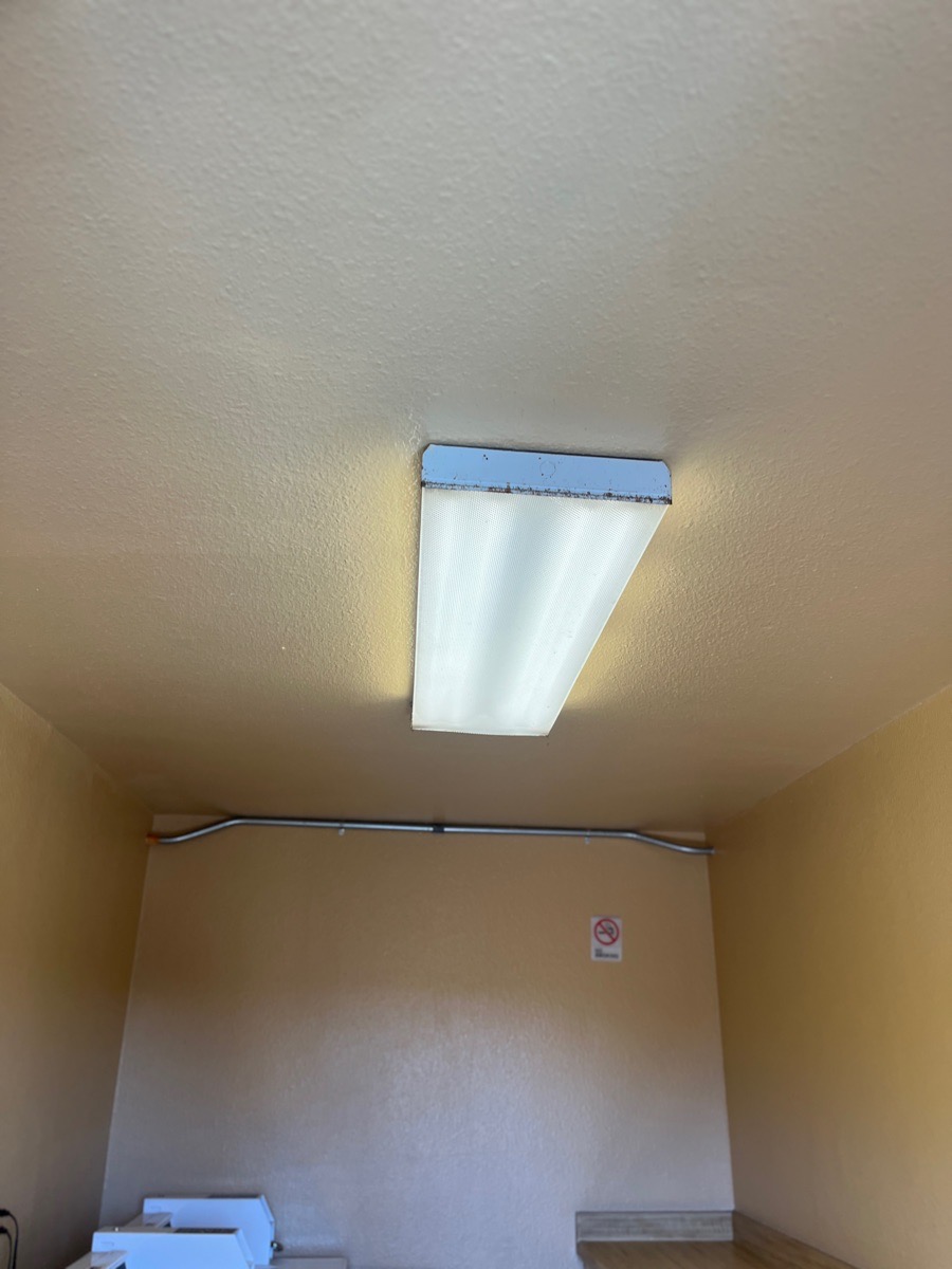 Illuminated rectangular fixture in a laundry-room ceiling after LED bulb replacements